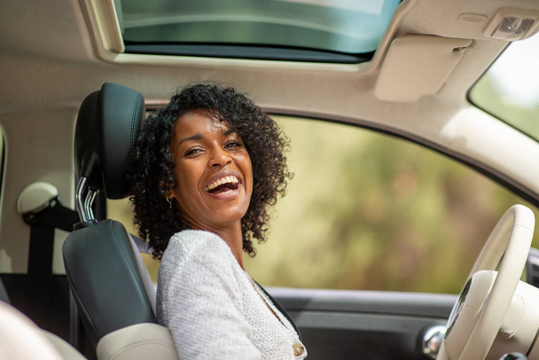 Portrait happy african american woman driving in car - Foto, Imagen