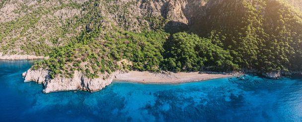 Aerial view of a remote beach among high mountains evokes a sense of freedom and adventure, inviting viewers to embrace the raw power of mediterranean sea - Foto, Bild