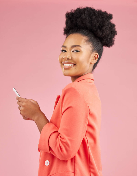 Afričanka, studio portrét a telefon s textovkou, web chat nebo kontakt s úsměvem na růžovém pozadí. Mladý módní model, student nebo gen z dívka s chytrým telefonem, krása a radost pro sociální média. - Fotografie, Obrázek