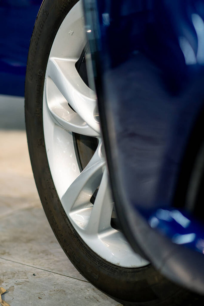 Zbliżenie koła niebieskiego samochodu koncepcja fascynacji samochodem i jego szczegóły dotyczące naprawy samochodu - Zdjęcie, obraz