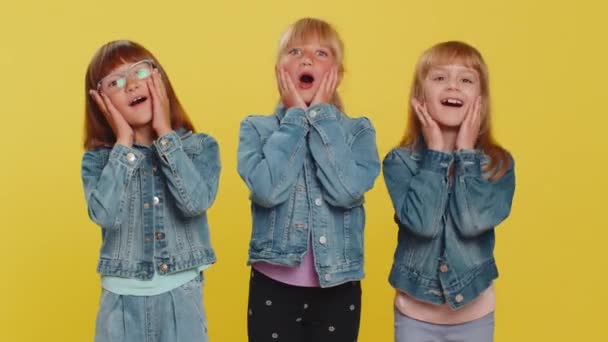 Oh my God, Wow. Little child sisters looking surprised at camera with big eyes, shocked by sudden victory, game winning lottery goal achievement, good news. Three siblings children kids. Teenage girls - Footage, Video