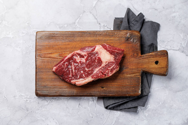 Roh Rindfleisch Ribeye Steak, frisch und bereit zum Kochen, verspricht ein köstliches kulinarisches Erlebnis. Flache Lage - Foto, Bild