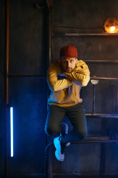 Hipster breakdancer yllään rento vaatteita poseeraa kameran yli parvi maanalainen metro tausta. B-boy hip hop tanssijan muotokuva - Valokuva, kuva