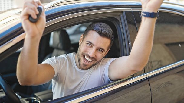 Fiatal spanyol férfi kezében kulcs új autó a győztes kifejezés az utcán - Fotó, kép