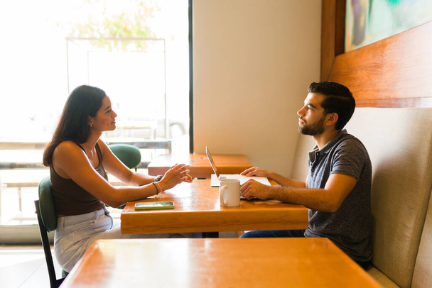 Hispánec mluví s mladou ženou, která hledá práci a má pracovní pohovor v kavárně - Fotografie, Obrázek