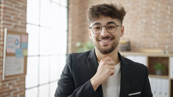 Jonge Arabische man zakenman glimlachend vol vertrouwen op kantoor - Foto, afbeelding