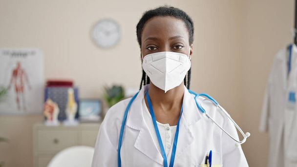 African american woman doctor wearing medical mask at clinic - Foto, immagini