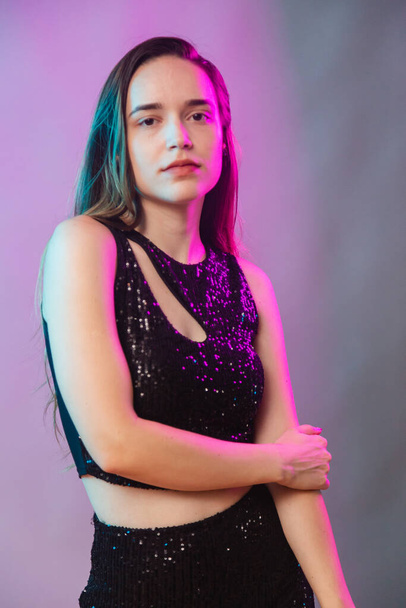 Model on blue and pink neon background, posing for photo, illuminated. vertical photo. - Foto, afbeelding