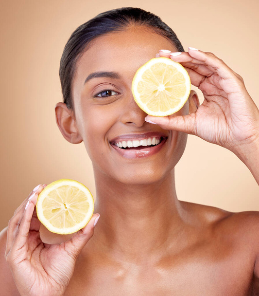 Lemon fruit, portrait and skincare of woman in studio for vitamin c benefits, eco cosmetics or nutrition. Face of indian female model, natural beauty and healthy citrus food for aesthetic dermatology. - Foto, imagen
