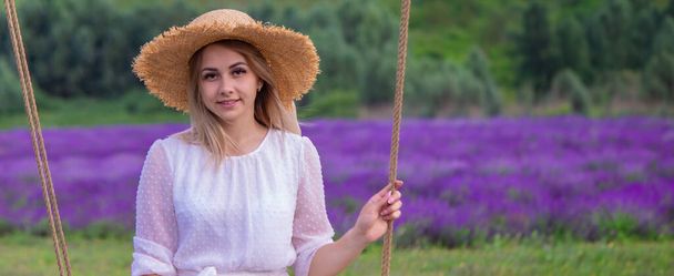 girl on a swing in a field of lavender. Selective focus. Nature - Photo, Image