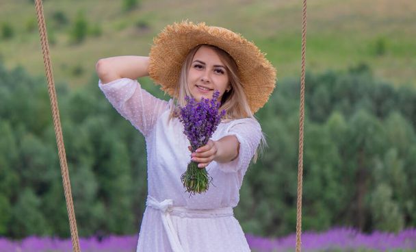 girl on a swing in a field of lavender. Selective focus. Nature - Photo, Image