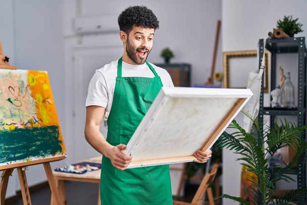 Homem árabe no estúdio de arte celebrando louco e espantado pelo sucesso com os olhos abertos gritando animado.  - Foto, Imagem