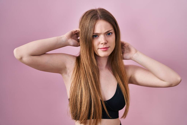 Young caucasian woman wearing lingerie over pink background skeptic and nervous, frowning upset because of problem. negative person.  - Foto, Imagem