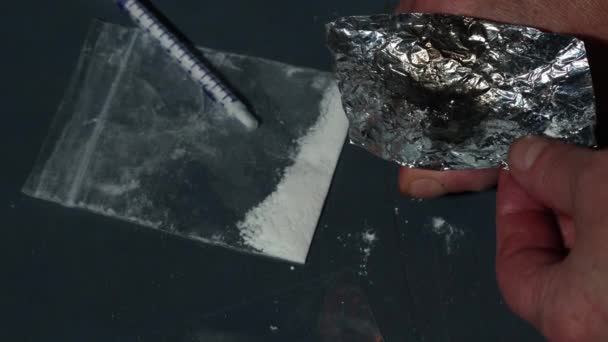Narkoman palący heroinę w folii zbliżenie slow motion zoom pokazać selektywną ostrość - Materiał filmowy, wideo