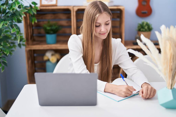 Fiatal fehér nő ül az asztalon tanul otthon - Fotó, kép