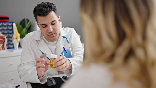 Мужчина и женщина врач и пациент назначают таблетки для лечения в клинике - Фото, изображение