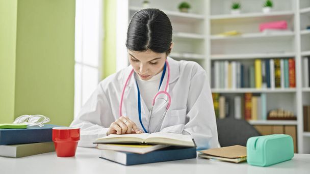Junge schöne hispanische Ärztin liest Buch an der Universität - Foto, Bild