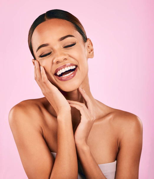 Funny, smile and woman with skincare, beauty and dermatology against a pink studio background. Female person, humor or happy model with makeup, wellness and facial with luxury, laughing and aesthetic. - Photo, Image