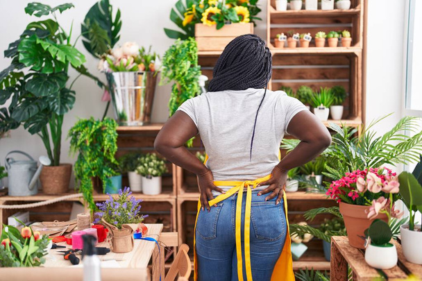 Floristería mujer afroamericana mirando estanterías en floristería - Foto, Imagen