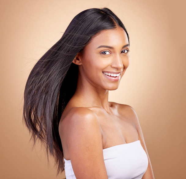Hairstyle, salon and beauty with indian woman healthy shine in brown studio background. Haircare, girl and happy with wind for growth or keratin treatment with shine and natural cosmetic in mockup - Fotoğraf, Görsel