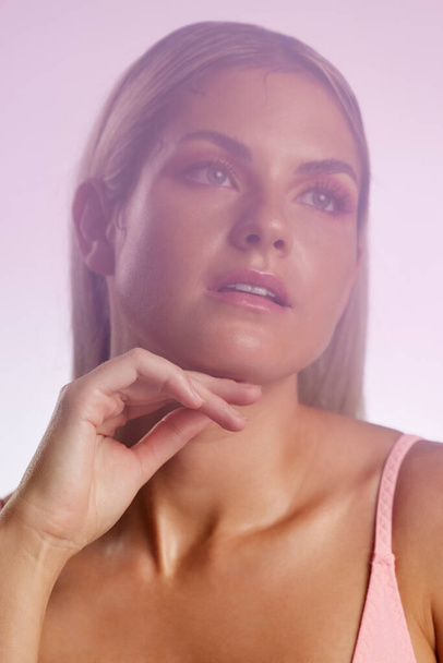 Beauty, makeup and young woman in a studio with a natural, glamour and luxury face routine. Cosmetic, attractive and female model from Australia with facial cosmetology isolated by a pink background - Fotó, kép
