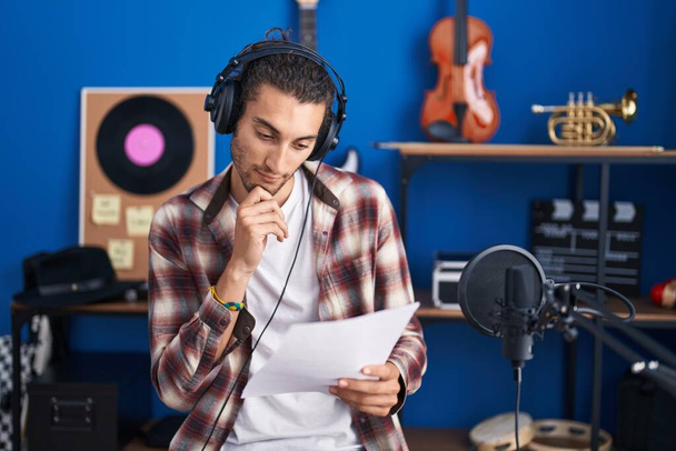 Young hispanic man musician singing song at music studio - 写真・画像