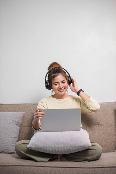 Portrait de jeune femme asiatique aiment écouter de la musique avec des écouteurs et en utilisant un ordinateur portable, temps heureux et relaxant.. - Photo, image