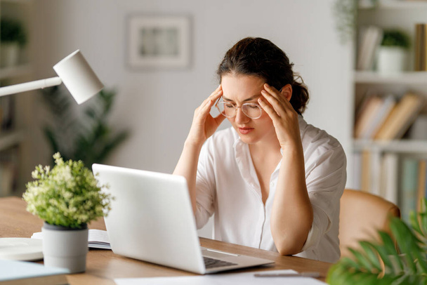 Young businesswoman working on laptop and having a head ache.  - Photo, Image