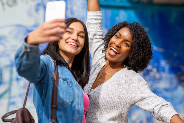 Portrait two cheerful female friends taking selfie with mobile phone - Zdjęcie, obraz