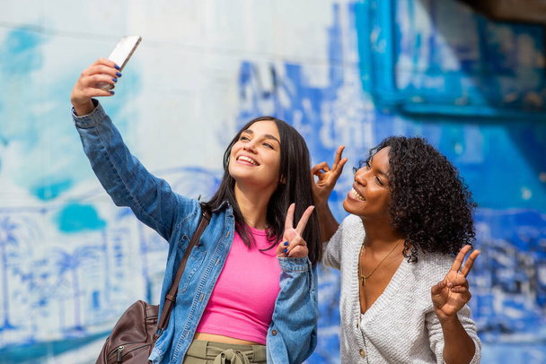 Portrait happy female friends taking selfie with mobile phone - 写真・画像