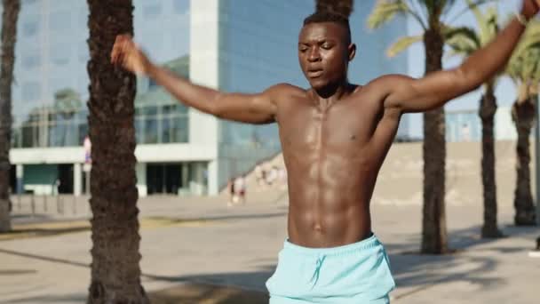 Vídeo en cámara lenta de un hombre africano deportivo haciendo saltos en un parque - Imágenes, Vídeo