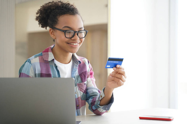 Happy African-American girl e-bankowość na laptopie, zakupy online z radością. - Zdjęcie, obraz