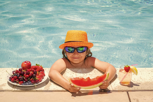 Child in swimming pool playing in summer water. Vacation and traveling with kids. Summer fruits for children - Photo, Image