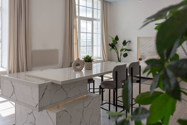 kitchen and dining island with high bar stools in a minimalistic modern luxury design of an expensive house on a sunny day. white walls with plaster, parquet, decorative lighting and no one inside - Fotó, kép