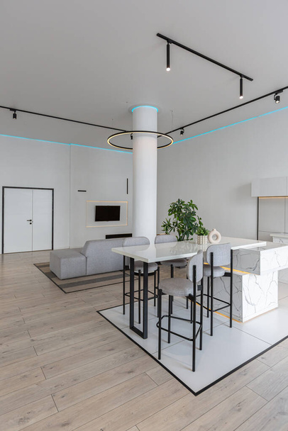 minimalistic modern luxury design of an expensive house with marble trim on a sunny day. white walls with plaster, parquet, decorative lighting and no one inside - Foto, afbeelding