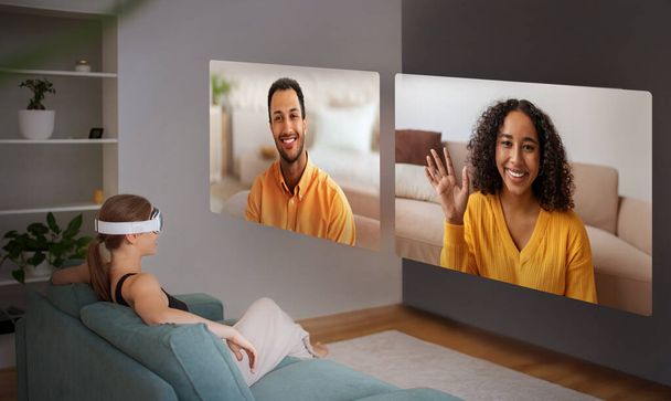 Леді в VR окулярах беруть участь у відеоконференції, сидячи на дивані вдома, дивлячись на цифрові екрани з різними молодими людьми, колаж. Віддалений онлайн-зв'язок, концепція ділового виклику - Фото, зображення