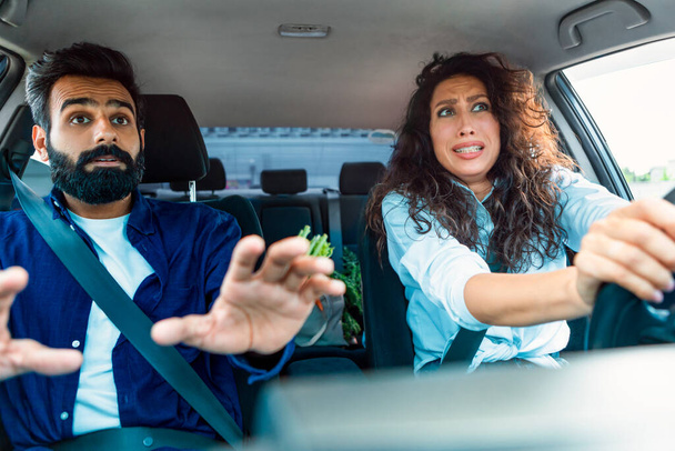Опасность движения. Стрессовая арабская пара, рискующая попасть в аварию, женщина за рулём. Проблемы транспортной безопасности, концепция аварий транспортных средств - Фото, изображение