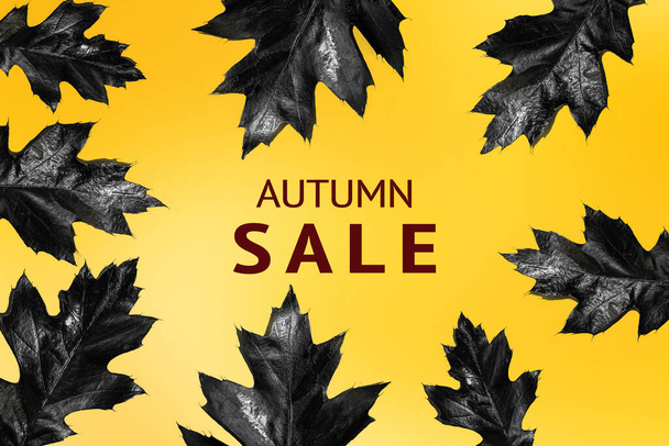 Cartas venta otoño y hojas de otoño negro sobre un fondo degradado amarillo. - Foto, imagen
