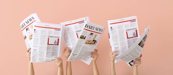 Weibliche Hände mit Zeitungen auf rosa Hintergrund - Foto, Bild