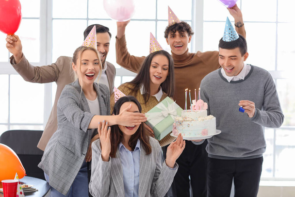 Ομάδα επιχειρηματιών που εκπλήσσουν το συνάδελφό τους με τούρτα γενεθλίων στο πάρτι στο γραφείο - Φωτογραφία, εικόνα