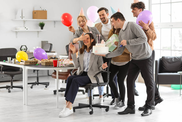 Üzletemberek csoportja, akik születésnapi tortával lepik meg kollégájukat az irodában. - Fotó, kép