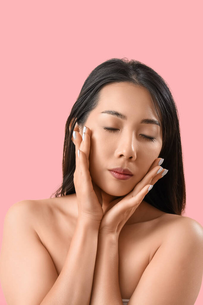 Hermosa mujer asiática con piel sana sobre fondo rosa - Foto, Imagen