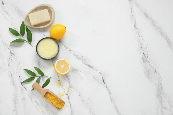 Bowl of lemon body scrub with soap and sea salt on grunge white background - Photo, Image