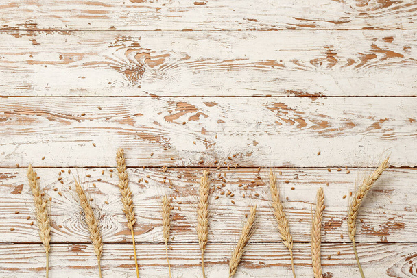 Orecchie e grani di grano su tavolo di legno bianco - Foto, immagini