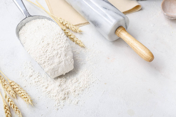 Scoop with wheat flour and rolling pin on white background - Valokuva, kuva