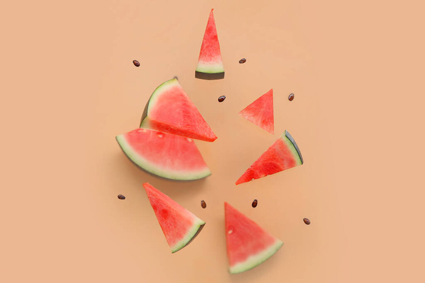 Flying pieces of fresh watermelon and seeds on beige background - Foto, Imagem