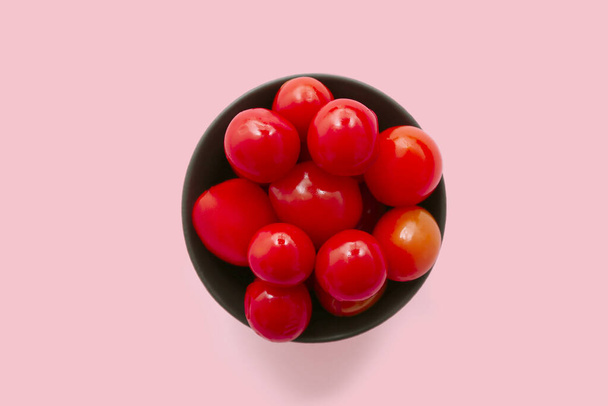 Schüssel mit Tomatenkonserven auf rosa Hintergrund - Foto, Bild