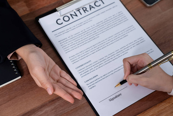 Closeup hand signing contract document with pen, sealing business deal with signature. Businesspeople finalizing business agreement by writing down signature on contract paper. Enthusiastic - Photo, Image