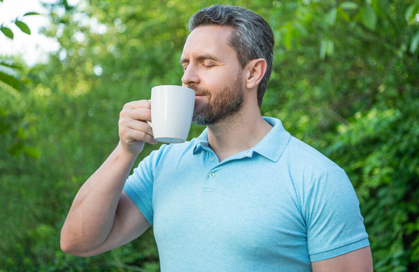 photo of man enjoy and smell coffee in the morning outdoor. - Fotó, kép