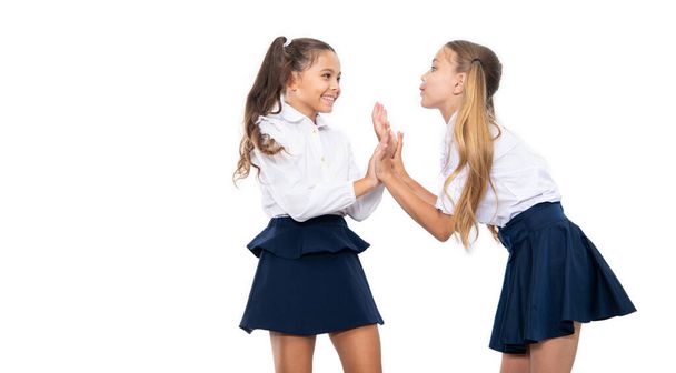 education and knowledge. children girls wearing uniform. high school education. school uniform fashion. children girls on desk. two girls in school uniform. happy childhood. - Foto, afbeelding